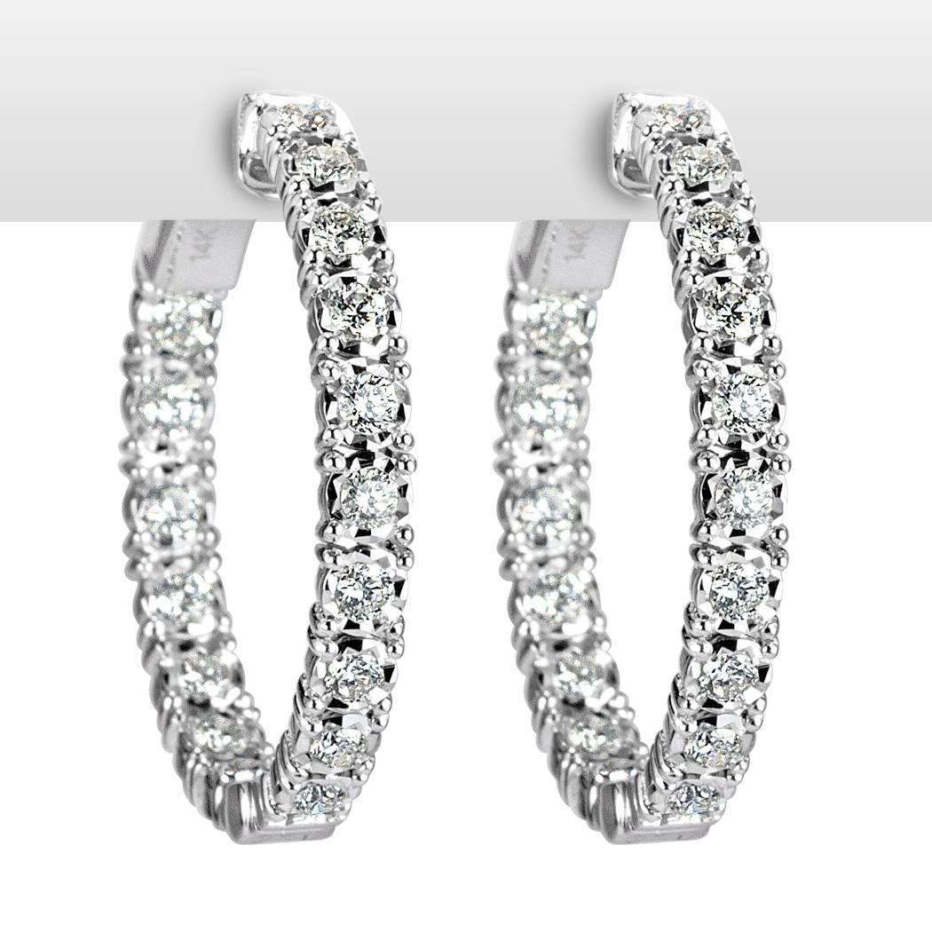 This stunning pair of diamond hoop earrings is set with 1.00ct of round brilliant cut diamonds graded at E-F, VS1-VS2. They are set in an inside-outside manner for maximum brilliance in this 14k white gold setting.