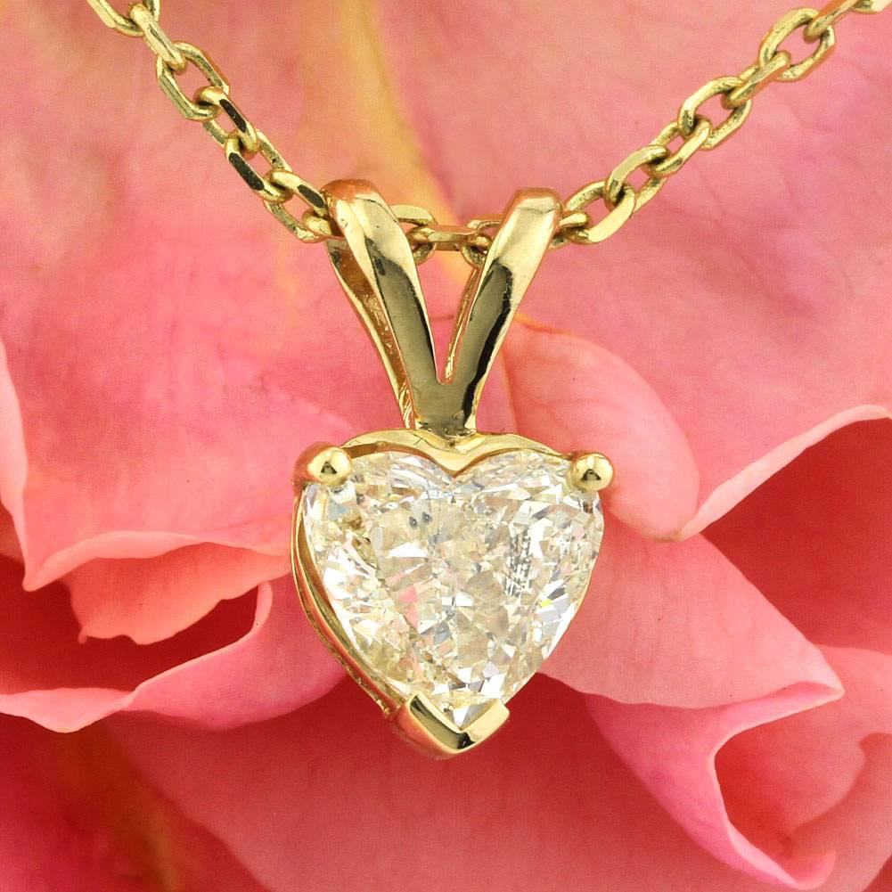 This diamond pendant features a beautiful 1.01ct heart shaped center diamond graded at Fancy Light Yellow-SI2. It is beautifully set in 14k yellow gold.