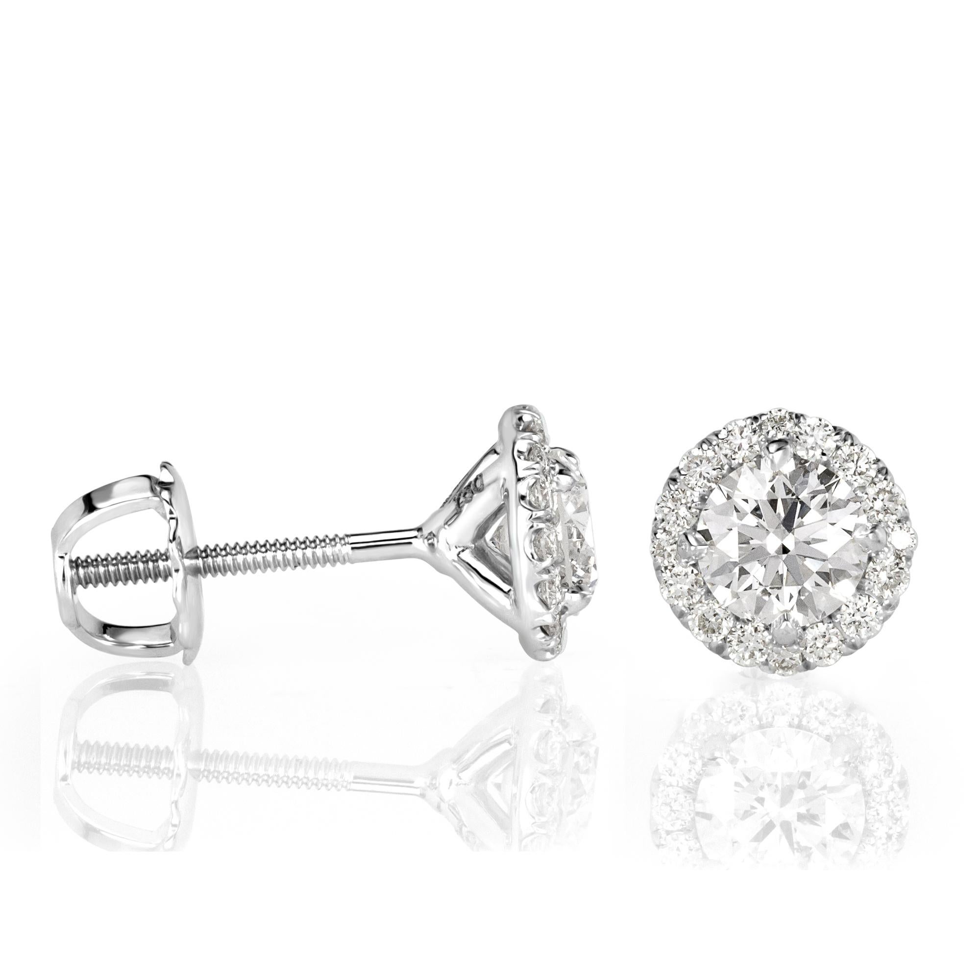 Custom created in 18k white gold, this mesmerizing pair of diamond stud earrings showcases two larger round brilliant cut diamonds each complimented by a dazzling micro pavé halo. The diamonds total 1.02ct in weight and are graded at F-G in color,