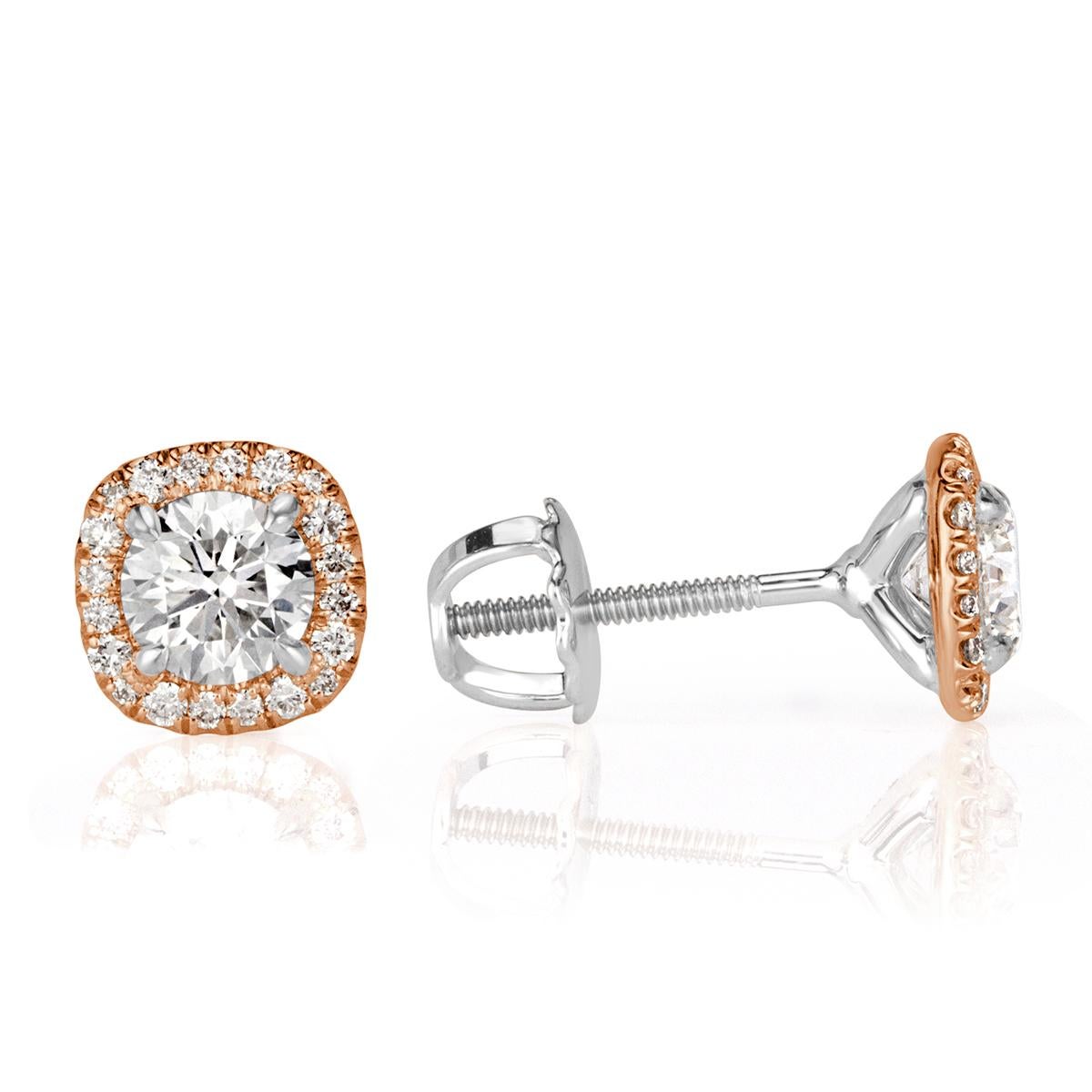 Custom created in 18k rose gold, this exquisite pair of diamond earrings showcases two larger round brilliant cut diamonds at the center individually surrounded by a shimmering cushion shaped halo of smaller round brilliant cut diamonds. The