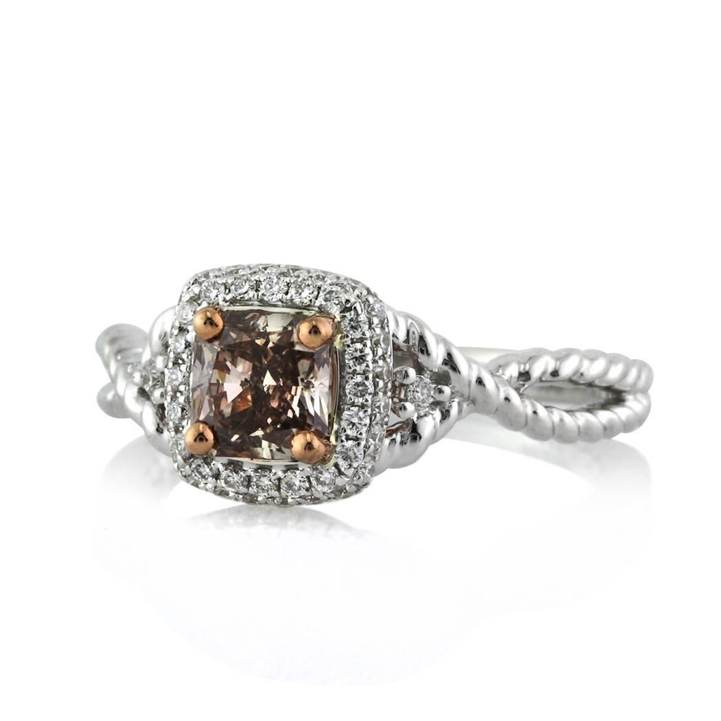 This beautiful fancy color radiant cut diamond ring features a beautiful 0.81ct cushion cut diamond set in the center of this handmade 18k white gold setting. It is GIA certified Fancy Dark Pinkish Brown, SI2. It is set in a two sided halo of white