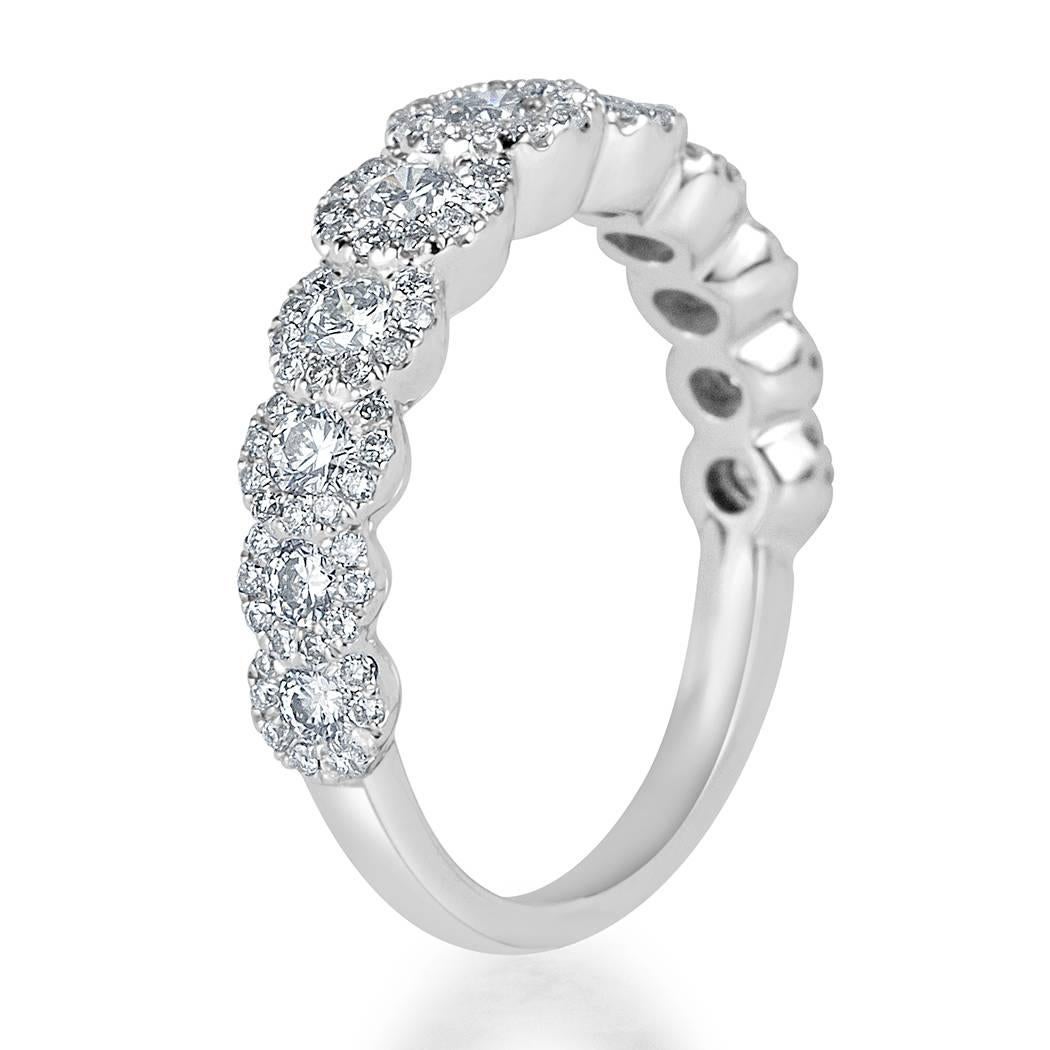 This beautiful diamond ring is set with 1.10ct of round brilliant cut diamonds graded at E-F, VS1-VS2. It showcases some larger diamonds each encased in a matching halo of smaller round diamonds set in 14k white gold.