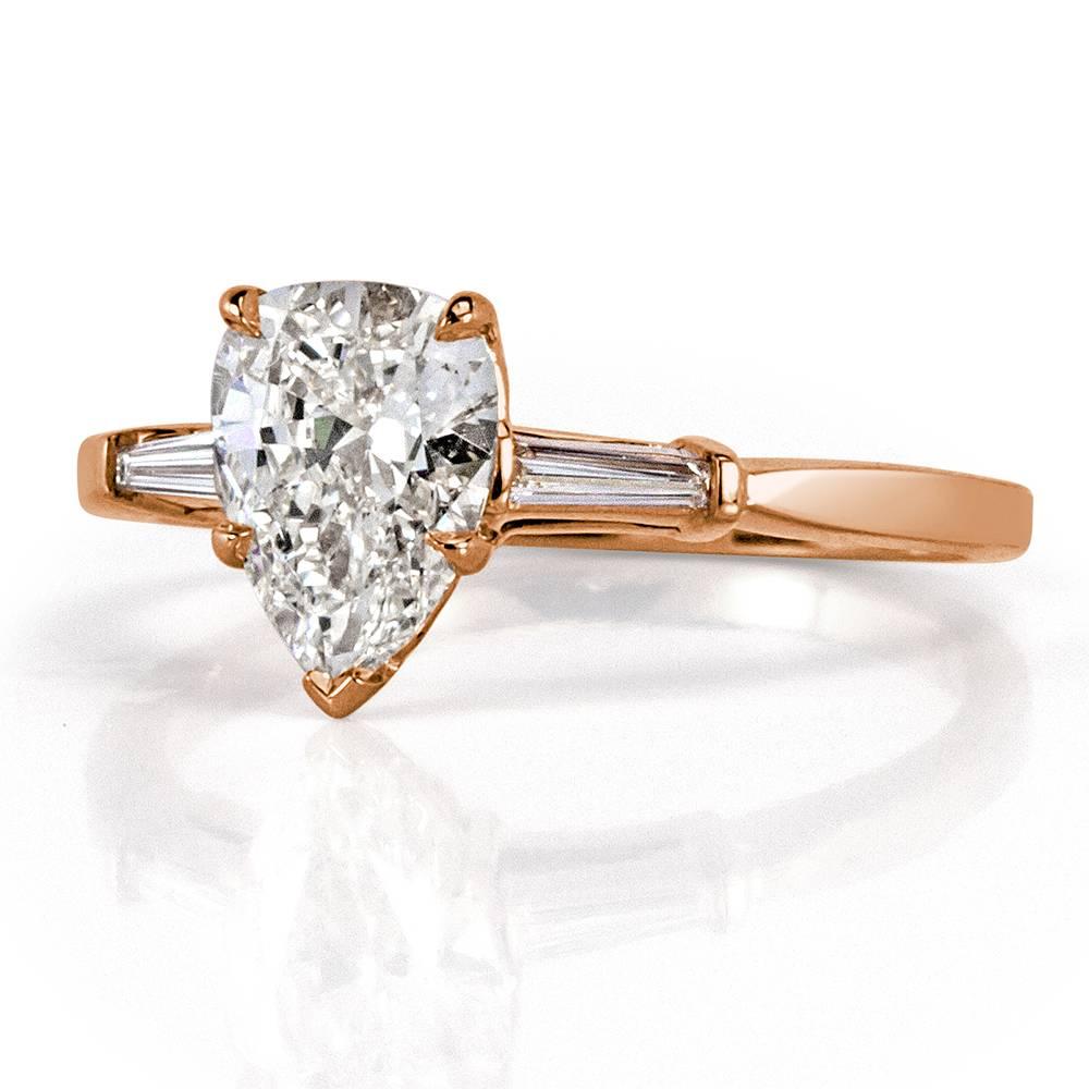 Created in 18k rose gold, this elegant diamond engagement ring features a beautiful 1.07ct pear shaped center diamond, GIA certified at J-VVS1. It is flanked by two baguette cut diamonds on either side. 