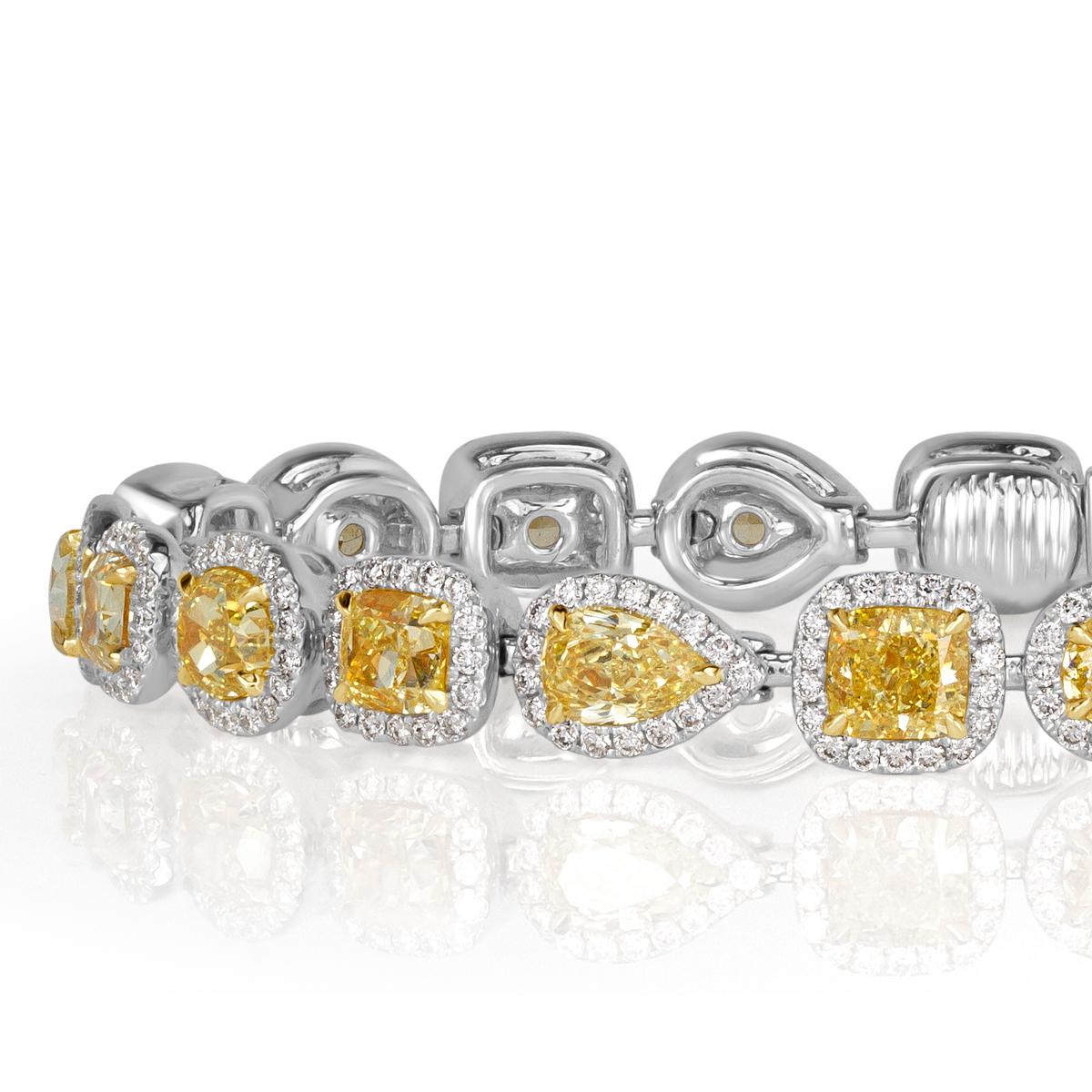 Gorgeous from every angle, this stunning diamond bracelet features larger fancy yellow diamonds of various shapes including round, cushion, oval and pear shaped diamonds. They are each accented by a halo of smaller white round brilliant cut