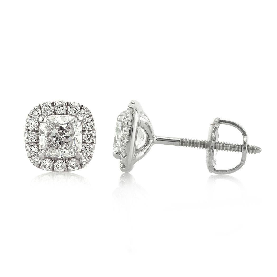 This gorgeous pair of diamond stud earrings is set with half carat cushion cut center diamonds GIA certified at E-F, SI1. They are perfectly matched with micro pave set halos of round diamonds surrounding each one of them. They are set in 18k white