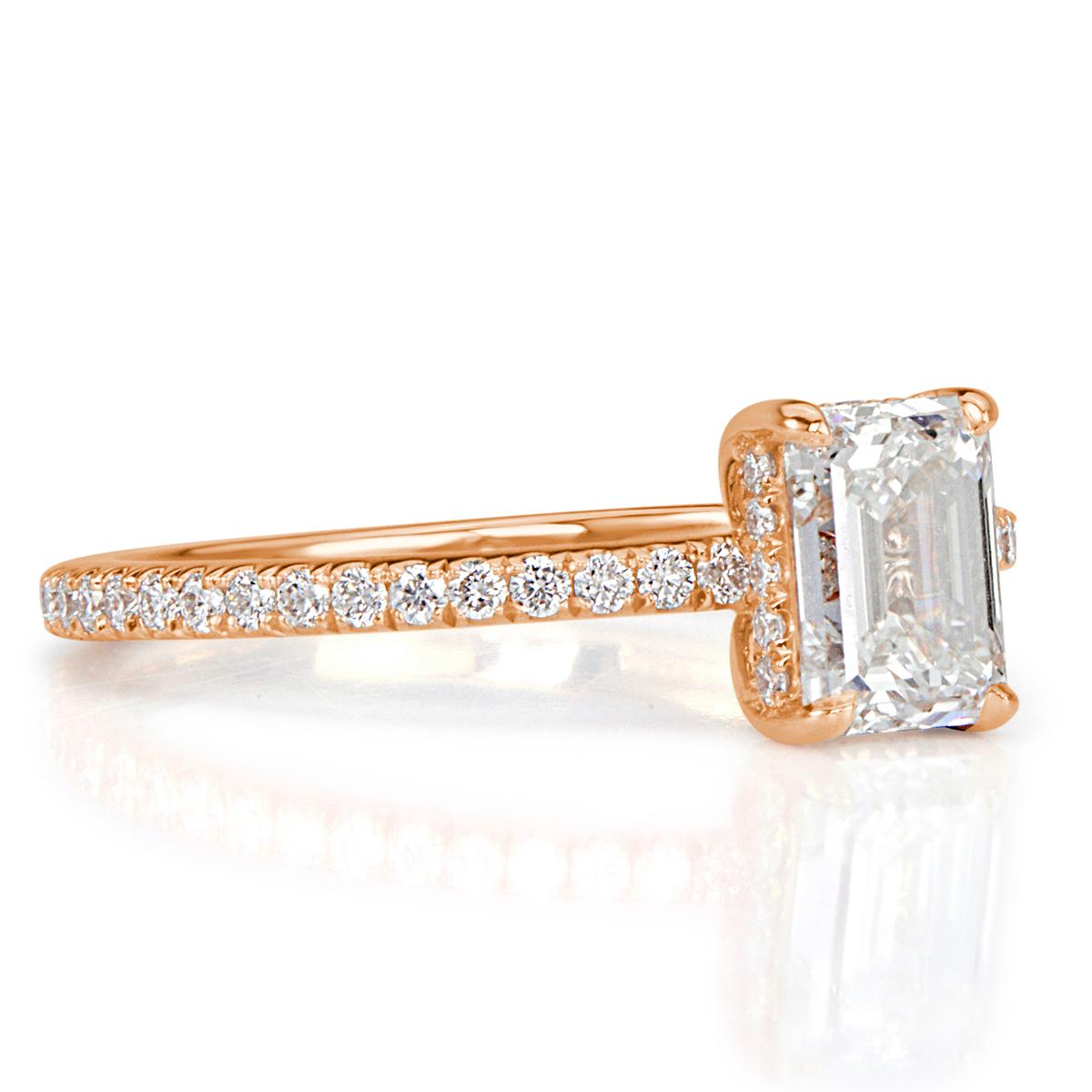 This exquisite diamond engagement ring showcases a stunning 1.02ct emerald cut center diamond, GIA certified at H-VVS2. It is accented by a hidden halo of round brilliant cut diamonds as well as sparkling diamonds micro pavé set down the 18k rose