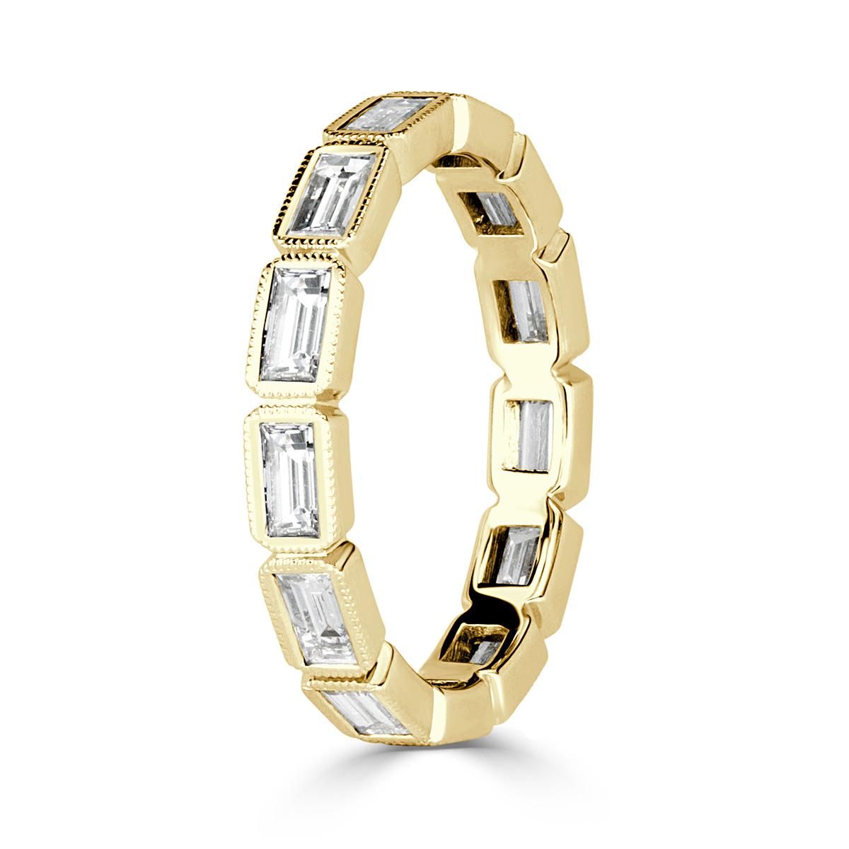 Created to perfection in 18k yellow gold, this stunning diamond eternity band showcases 1.40ct of perfectly matched baguette cut diamonds graded at E-F in color, VS1-VS2 in clarity. They are each accented with exquisite milgrain detain throughout.