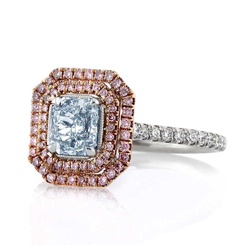 This one-of-a-kind diamond engagement ring features a ravishing 0.82ct radiant cut center diamond, GIA certified at Fancy Light Blue-SI1. It is accented by a double halo of fancy pink diamonds as well as one row of shimmering diamonds micro pavé set