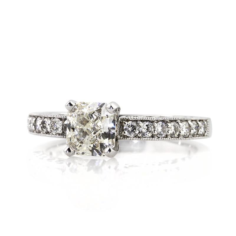 This delightful diamond engagement ring is set with a beautiful 1.04ct radiant cut center diamond, EGL certified at H-VVS2. It is poised atop a unique 18k white gold shank featuring one row of round diamonds set half way around the ring in a pavé