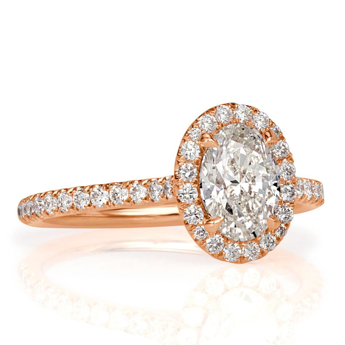 Handcrafted in 18k rose gold, this ravishing diamond engagement ring features an exquisite 1.01ct oval cut center diamond, GIA certified at H-SI1. It is accented by a halo of round brilliant cut diamonds with one row of sparkling shimmering diamonds