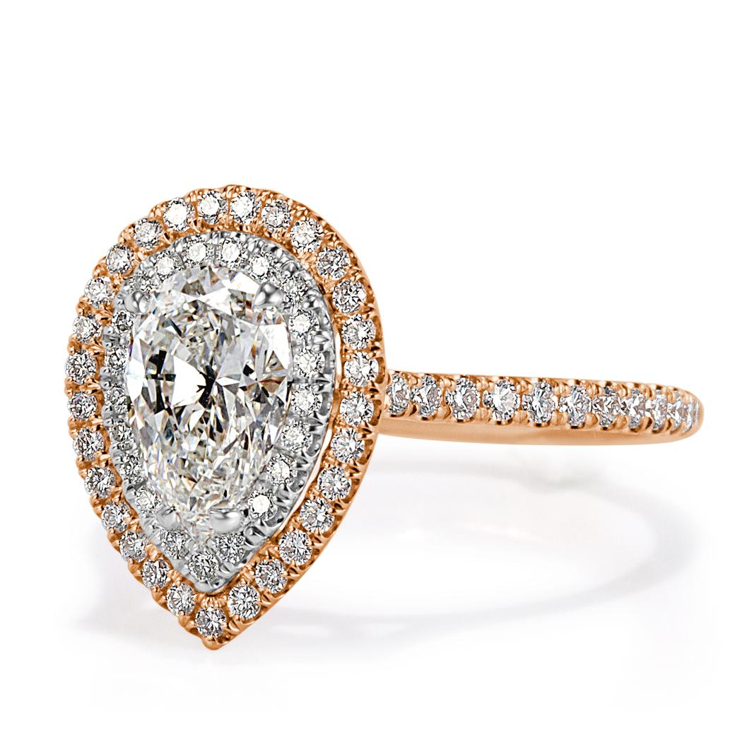 Custom created in 18k white gold and 18k rose gold, this ravishing diamond engagement ring showcases a 0.90ct pear shaped center diamond, GIA certified at H-VS2. It is accented by a double halo of round brilliant cut diamonds as well as one row of