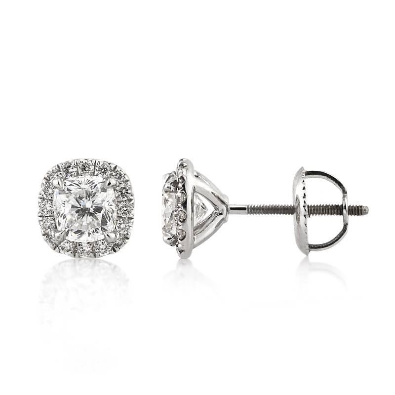 This stunning pair of diamond earrings features two gorgeous cushion cut  diamonds with a total weight of about 1.30ct. They are each accented by a halo of round brilliant cut diamonds. The accent diamonds total 0.30ct in weight and graded at E-F,