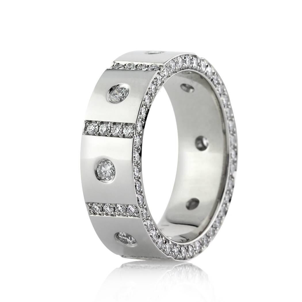 Custom created in platinum, this diamond eternity band features a 6mm width and showcases larger round brilliant cut diamonds set in a flush setting on top, each accented with one row of round diamonds pavé set in between them. The front and back of