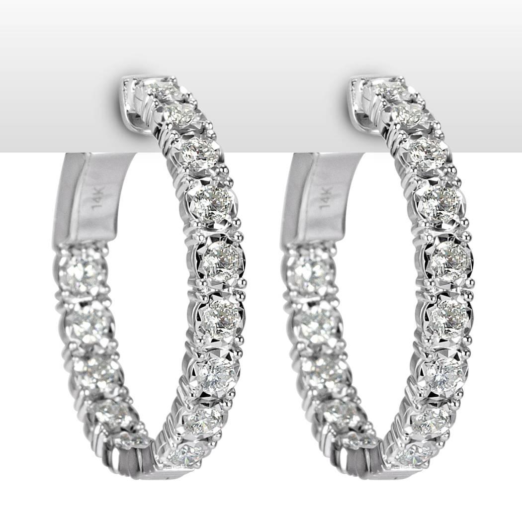 This stunning pair of diamond hoop earrings is set with 1.50ct of round brilliant cut diamonds graded at E-F, VS1-VS2. They are perfectly matched and hand set in an inside-outside manner for minimal metal showing.