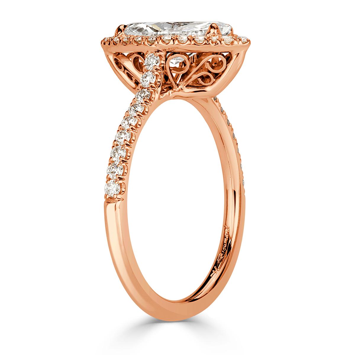 Custom created in 18k rose gold, this ravishing diamond engagement ring showcases an exquisite 1.14ct marquise cut center diamond, GIA certified at I-SI1. It is accented by a matching halo of round brilliant cut diamonds as well as one row of