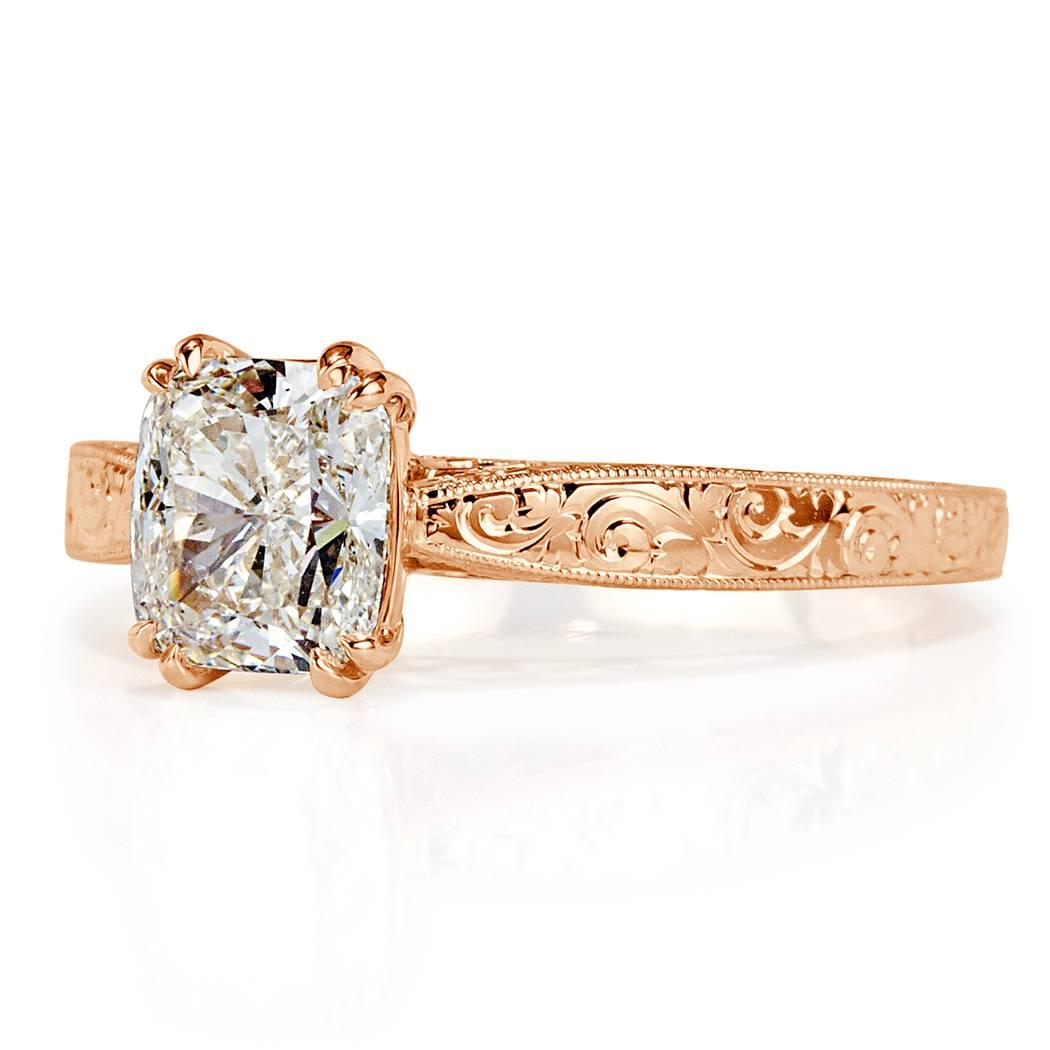This stunning solitaire diamond engagement ring showcases a beautiful 1.52ct cushion cut center diamond, GIA certified at K-VS1. It is set in a beautiful 18k rose gold setting featuring delicate hand engraved details throughout. The side of the ring