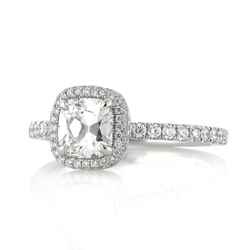 Custom created in platinum, this ravishing diamond engagement ring features a lovely 0.90ct old Mine cut center diamond, GIA certified at D-SI1. It is accented by a matching halo of round brilliant cut diamonds as well as one row of shimmering