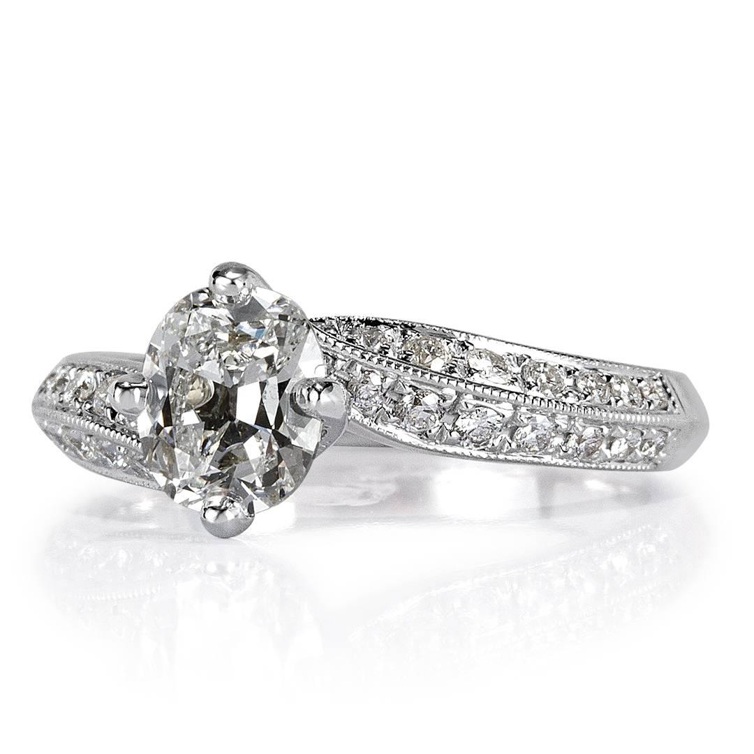 This diamond engagement ring showcases a stunning 1.01ct old Mine cut diamond, GIA certified at G-SI2. It is accented by 0.60ct of round brilliant cut diamonds pavé set on the very unique band. The diamonds are embedded into hand milgrain detail and