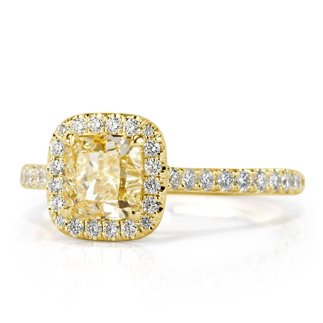 This beautiful diamond engagement ring features a 1.21ct cushion cut center diamond GIA certified at Fancy Light Yellow-VS1. It is surrounded by 0.40ct of white round brilliant cut diamonds hand set in 18k yellow gold. All of the side diamonds are
