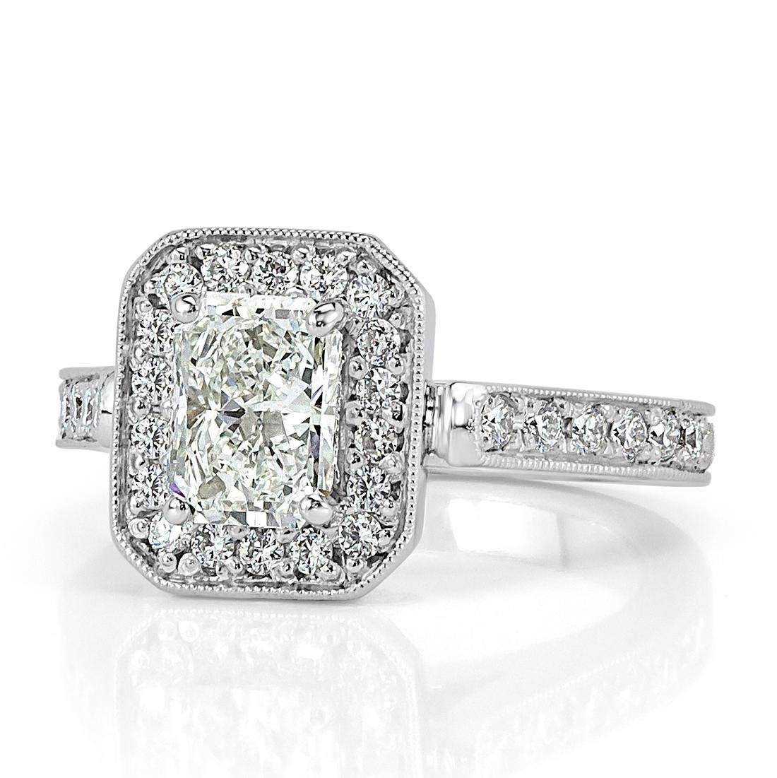 This superb diamond engagement ring features a 1.03ct radiant cut center diamond, GIA certified at H-VS2. It is complimented by a sparkling halo of round brilliant cut diamonds and one row of diamonds pavé set around the band. The diamonds are