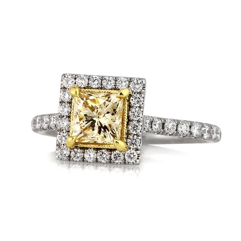 Custom created in platinum, this gorgeous piece features a stunning 1.02ct princess cut center diamond, GIA certified at fancy light brown yellow-SI1. It is beautifully showcased in a yellow gold center basket and encased in a shimmering halo of