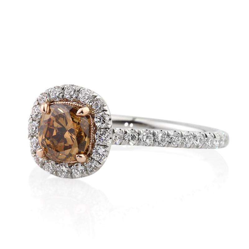 This elegant diamond engagement ring features a 1.02ct cushion cut center diamond, GIA certified at Fancy Yellow Brown-SI2. It is accented by a shimmering micro pavé halo as well as one row of round brilliant cut diamonds set around the dainty