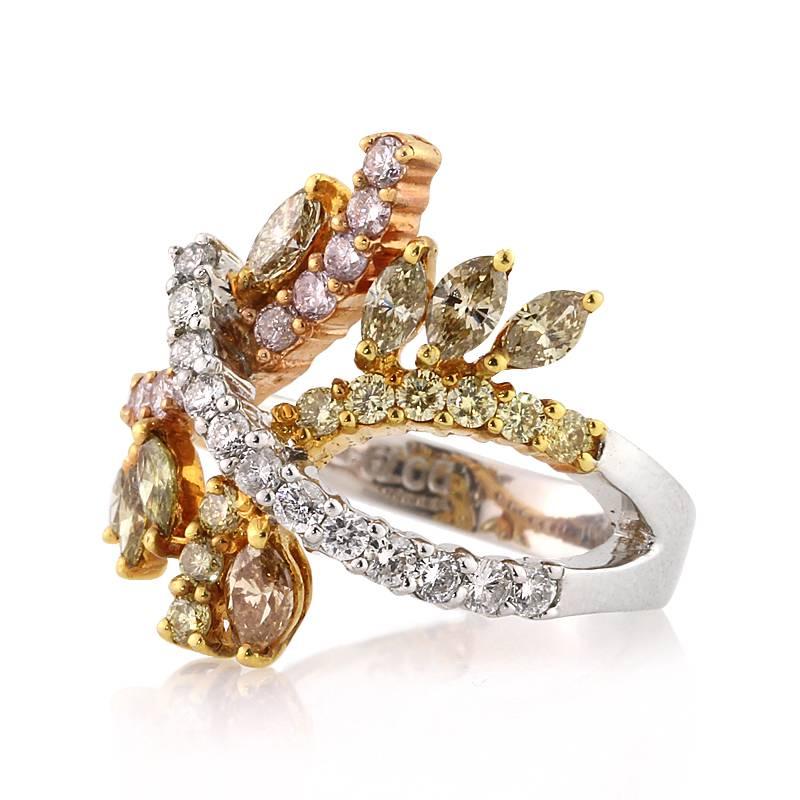 This stunning two-tone diamond right-hand ring showcases 1.70ct of marquise and round brilliant cut diamonds graded at VS2-SI2. With different shades of fancy colored diamonds hand set in 18k rose and white gold, the ring consists of intricate