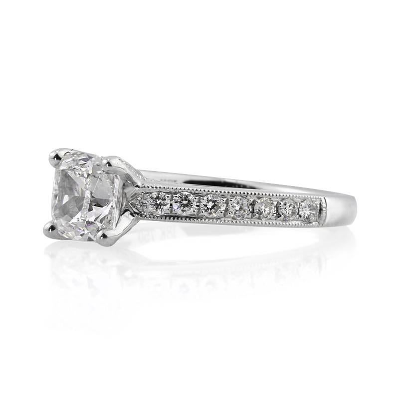 This exquisite diamond engagement ring showcases a beautiful 1.21ct cushion cut center diamond, GIA certified at F-SI1. It is set atop an elegant 18k white gold shank featuring one row of pavé set diamonds and for added sparkle, the unique center