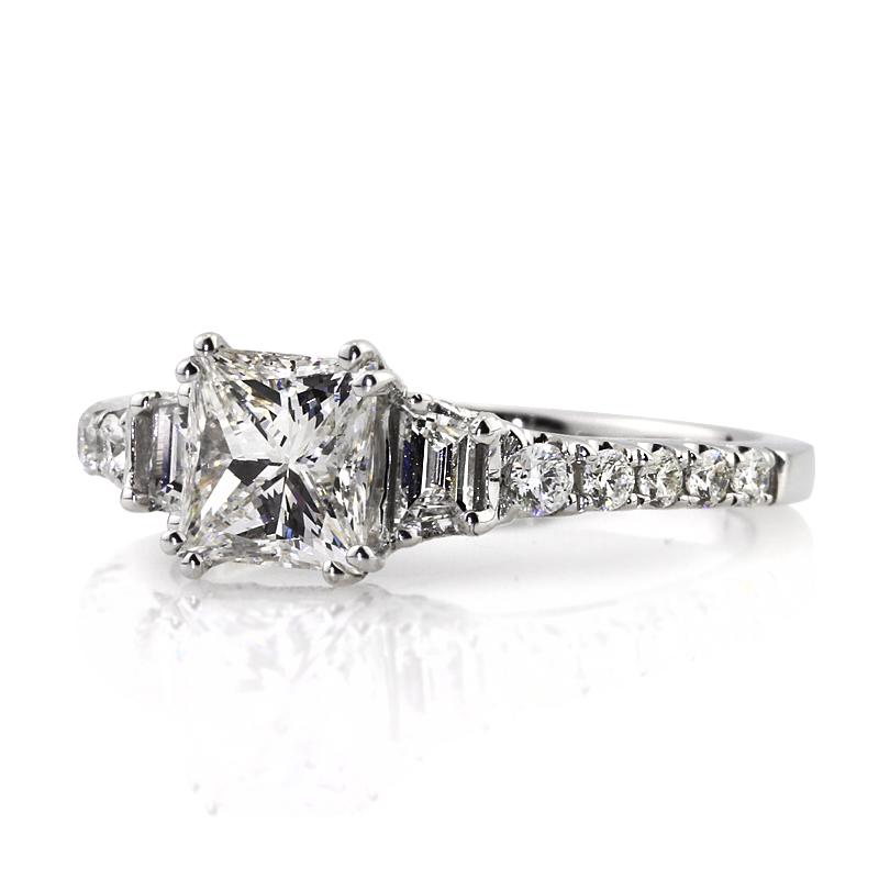 This ravishing diamond engagement ring showcases a 1.08ct princess cut center diamond, GIA certified at F-VS1. It is beautifully accented by two trapezoid cut diamonds on either side as well as one row of round brilliant cut diamonds studded on the