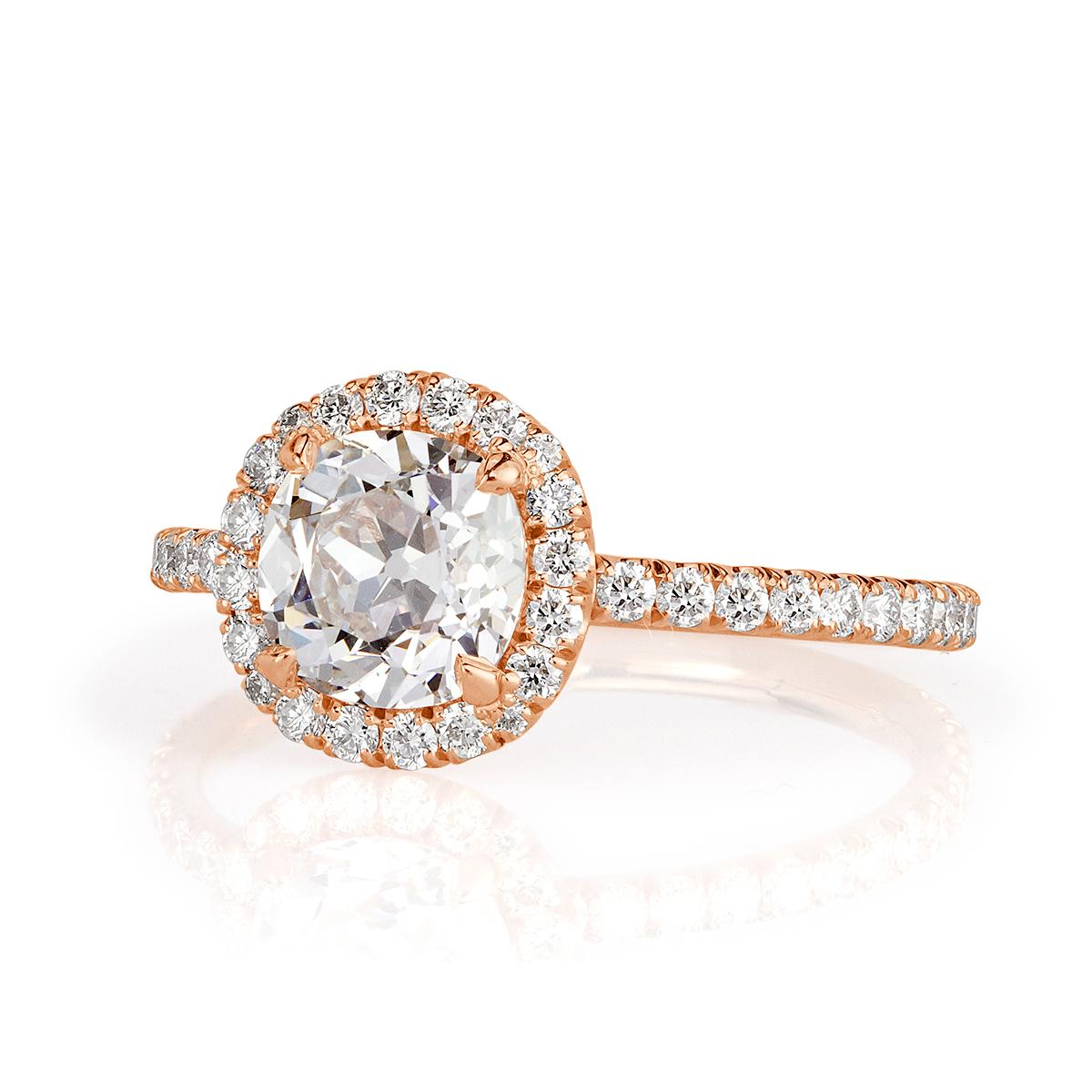 Custom created in 18k rose gold, this enchanting diamond engagement ring showcases a 1.20ct old Mine cut center diamond, GIA certified at E-SI1. It is accented by a shimmering round halo of round brilliant cut diamonds as well as sparkling diamonds