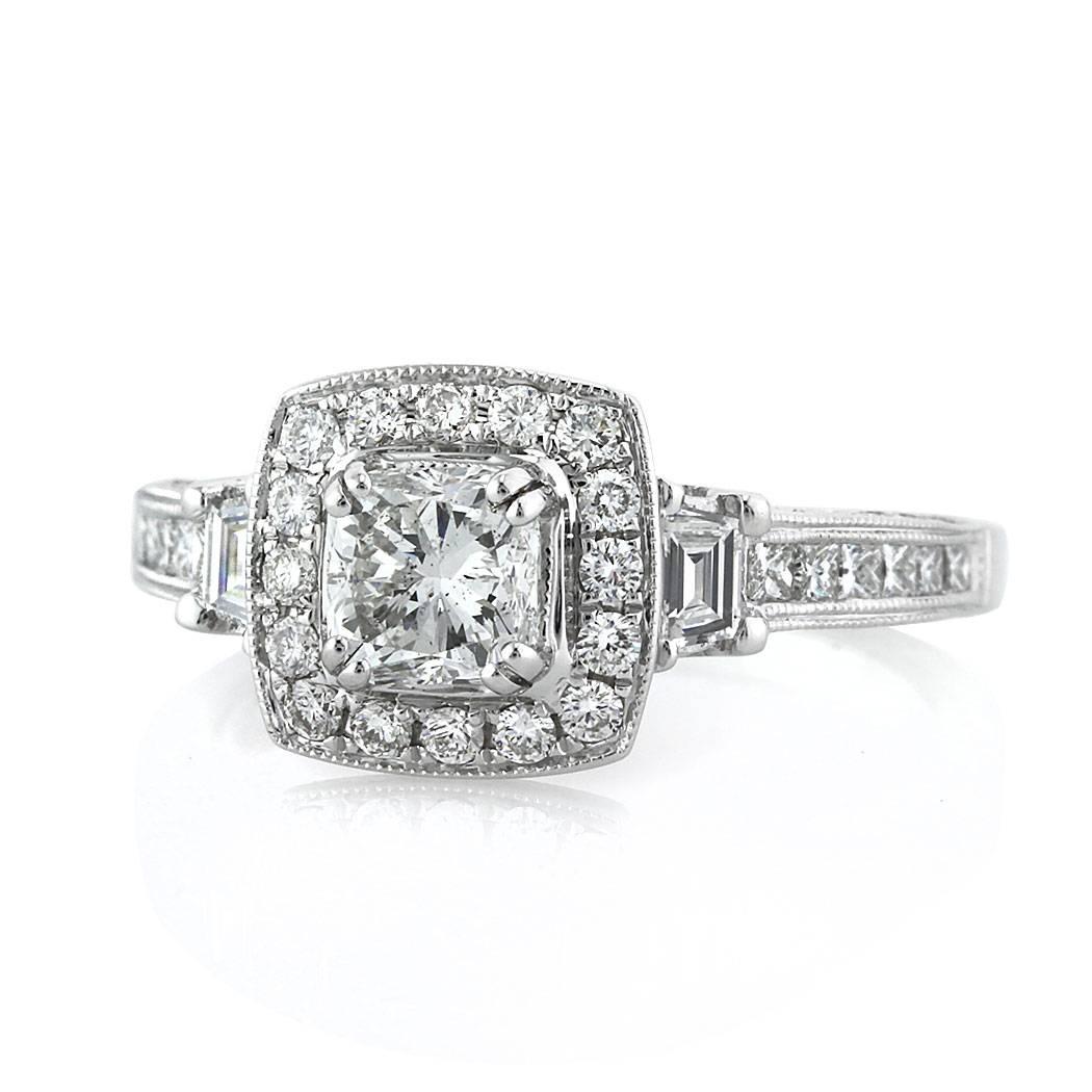This very unique diamond engagement ring features a lovely 0.75ct cushion cut center diamond graded at F-SI1. It is accented by a halo of round brilliant cut diamonds in a pave setting style which is flanked by two step cut trapezoids as well as one