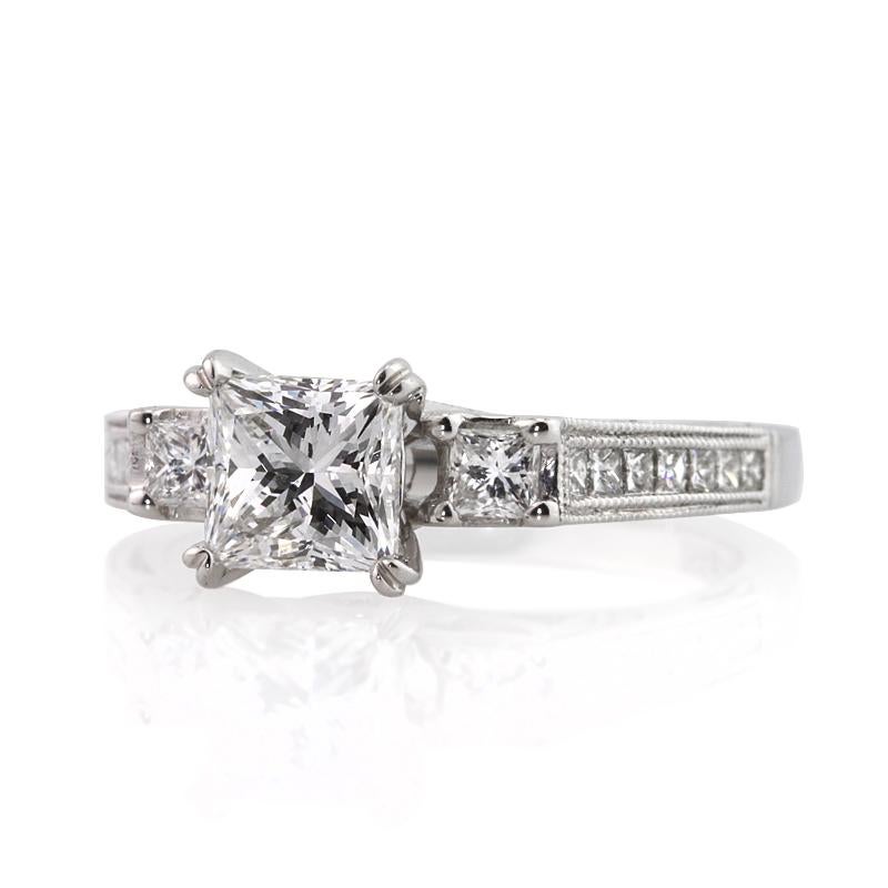 This beautiful diamond engagement ring showcases a 1.03ct princess cut diamond, GIA certified at E-VS1. It is flanked by two smaller princess cut diamonds on both sides as well as one row of round brilliant cut diamonds channel set half way down the