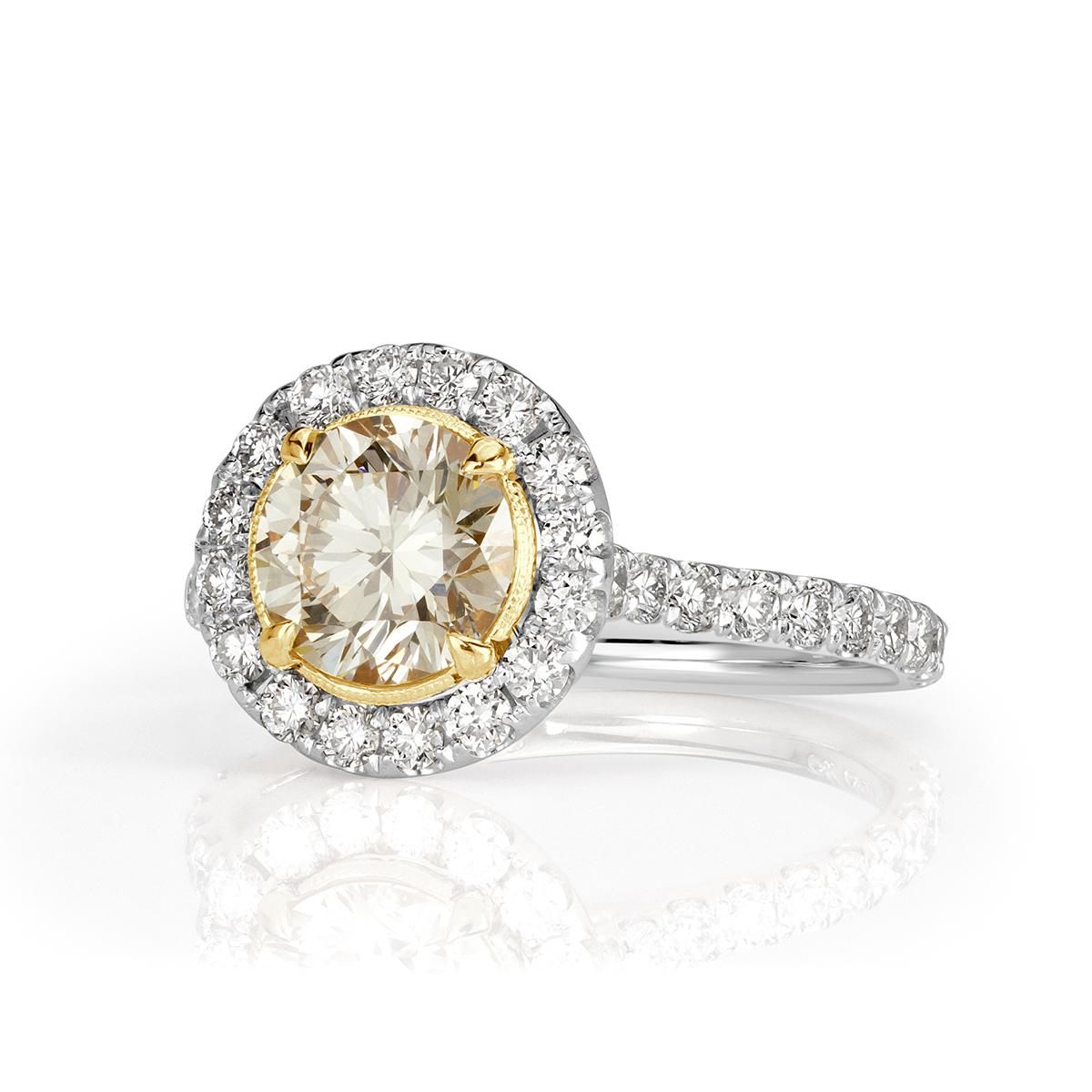 This lovely diamond engagement ring showcases a 1.22ct round brilliant cut center diamond, GIA certified at Fancy Light Yellow-VVS1. It is accented by a halo of peerless white round brilliant cut diamonds as well as one row of gleaming diamonds