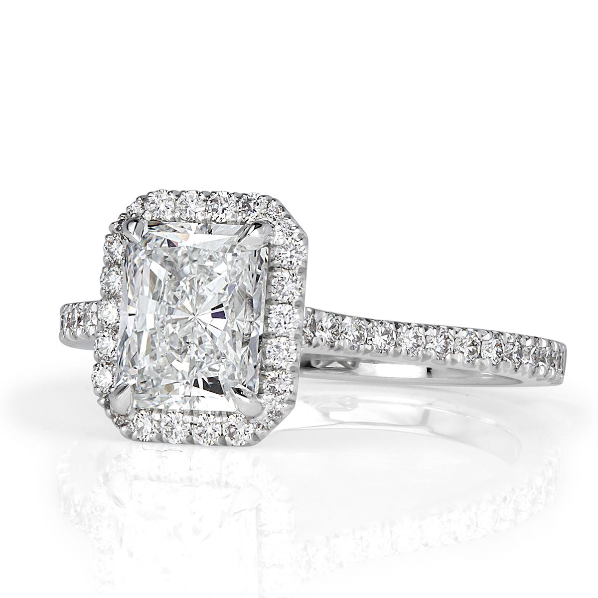Created in high polish platinum, this stunning diamond engagement ring showcases a gorgeous 1.52ct radiant cut center diamond, GIA certified at H-VVS1. It measures an incredible 7.76 x 6.03mm! It is complimented by a dainty halo of round brilliant