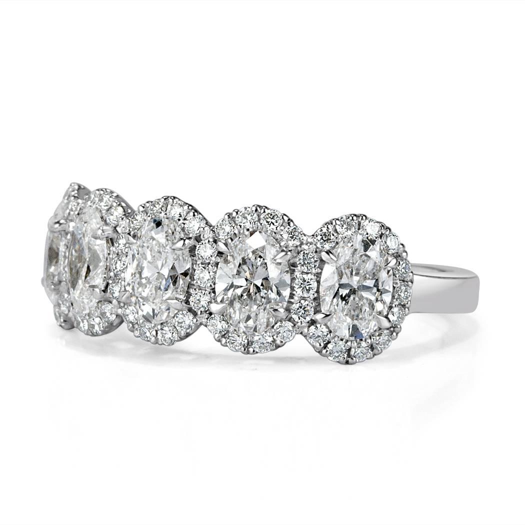 This five-stone ring is set with 1.62ct of perfectly matched oval cut diamonds graded at E-F, VS1-VS2. They are each surrounded by matching halos of round brilliant cut diamonds in this 18k white gold setting.