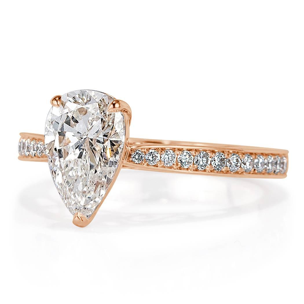 This gorgeous diamond engagement ring features an exquisite 1.62ct pear shaped center diamond, GIA certified at I-I1. It is set in a custom 18k rose gold setting showcasing one row of round brilliant cut diamonds pavé set on either side. The accent