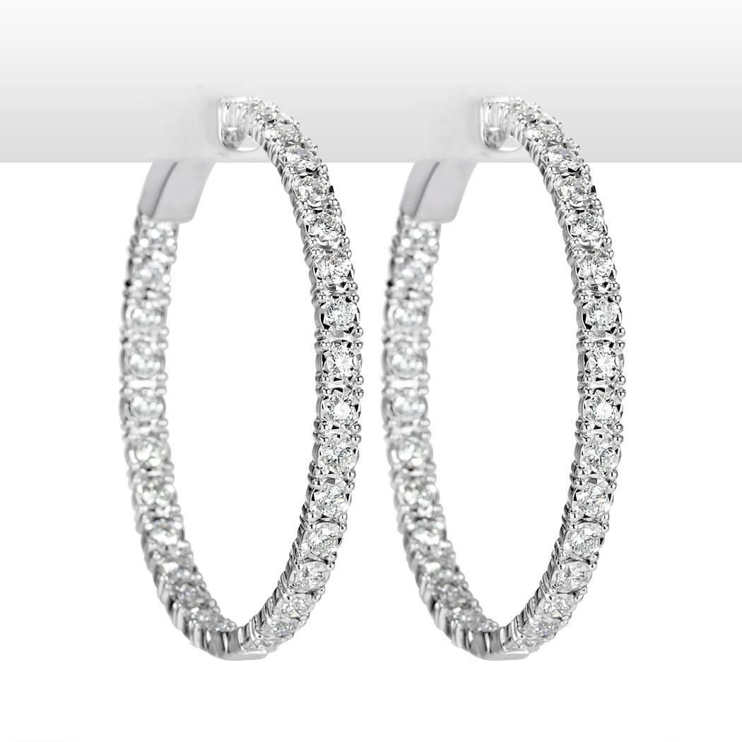 These diamond hoop earrings are set with 2.00ct of round brilliant cut diamonds graded at E-F, VS1-VS2. They are beautifully set in 14k white gold in an inside-outside manner for intense sparkle.