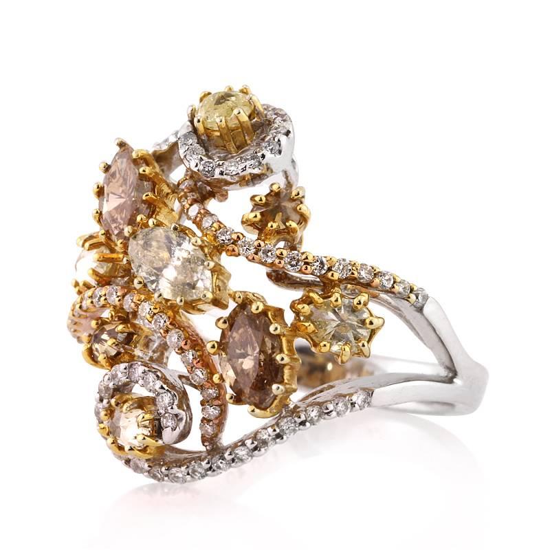 This stunning two-tone right-hand ring showcases 2.02ct of round brilliant cut, marquise cut and pear shaped diamonds. With different shades of stunning fancy colored diamonds, the ring consists of beautiful intricate designs. The diamonds are