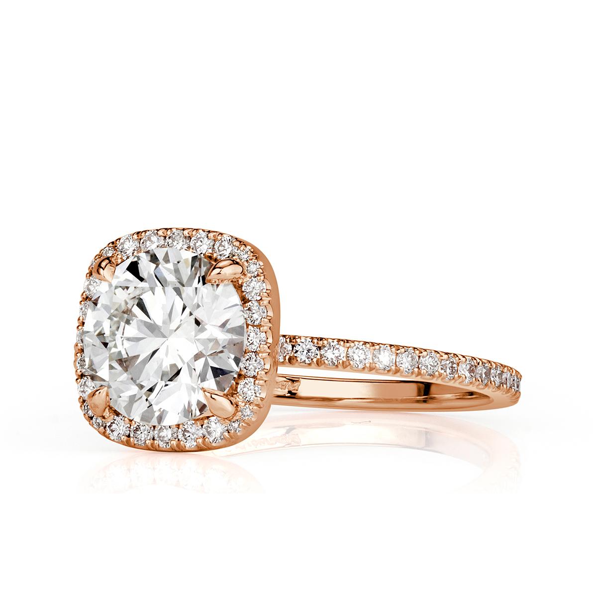 Custom created in 18k rose gold, this gorgeous diamond engagement ring showcases a stunning 1.70ct round brilliant cut center diamond, GIA certified at I-VS2. It is complimented by a dazzling cushion shaped halo of round brilliant cut diamonds as