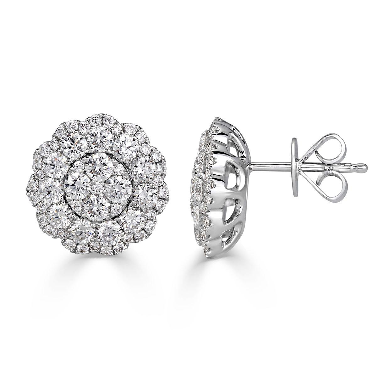 Custom created in 14k white gold, this beautiful pair of diamond stud earrings showcases 2.08ct of round brilliant cut diamond set in a whimsical floral pattern. The diamonds are graded at E-F in color, VS1-VS2 in clarity.