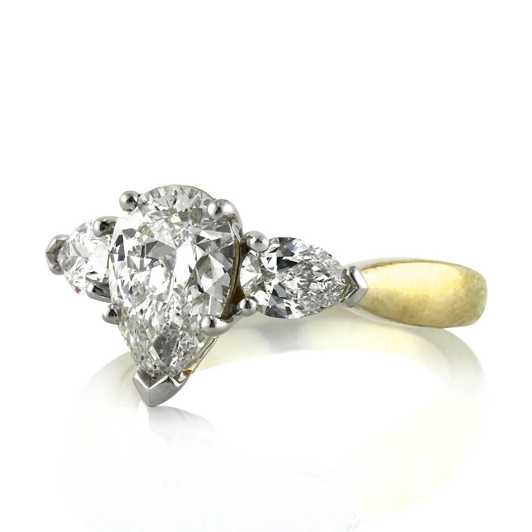This beautiful three-stone diamond engagement ring features a gorgeous 1.54ct pear shaped center diamond, GIA certified at G-VS1. It is accented by two perfectly matched pear shaped diamonds flanked on its sides and set in a custom 18k yellow gold