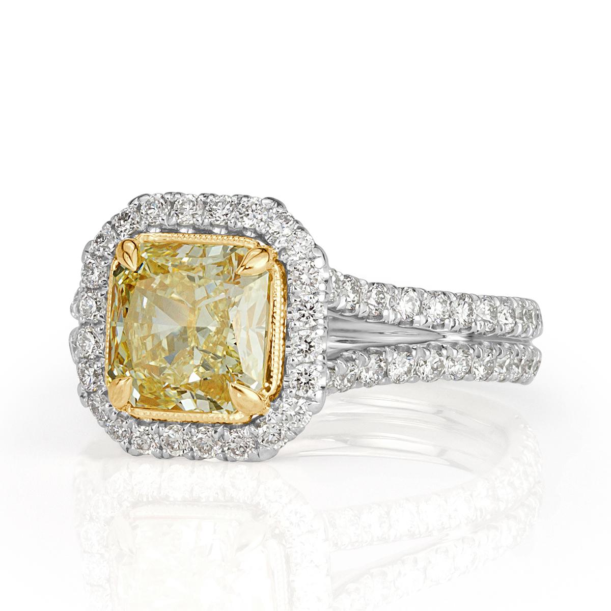 Designed in platinum, this gorgeous diamond engagement ring showcases a a gorgeous 1.38ct radiant cut center diamond, GIA certified at Fancy Yellow-VS1. It is complimented by a sparkling halo of white, round brilliant cut diamonds as well as two