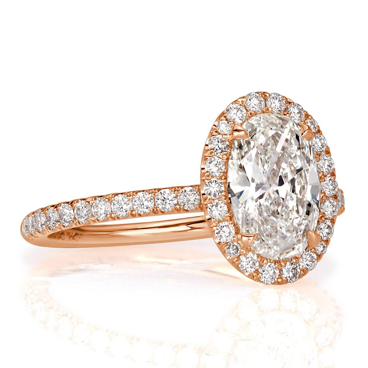 Custom created in 18k rose gold, this beautiful diamond engagement ring showcases a gorgeous 1.74ct oval cut center diamond, GIA certified at I in color, VS1 in clarity. It is has a stunning cut and sparkles with tremendous brilliance. It is