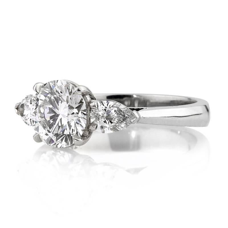 This stunning diamond engagement ring showcases a superb 1.72ct round brilliant cut center diamond, GIA certified at G-IF. It is accented by two pear shaped diamonds totaling 0.55ct in weight and graded at G-VS1. The diamonds are beautifully set in