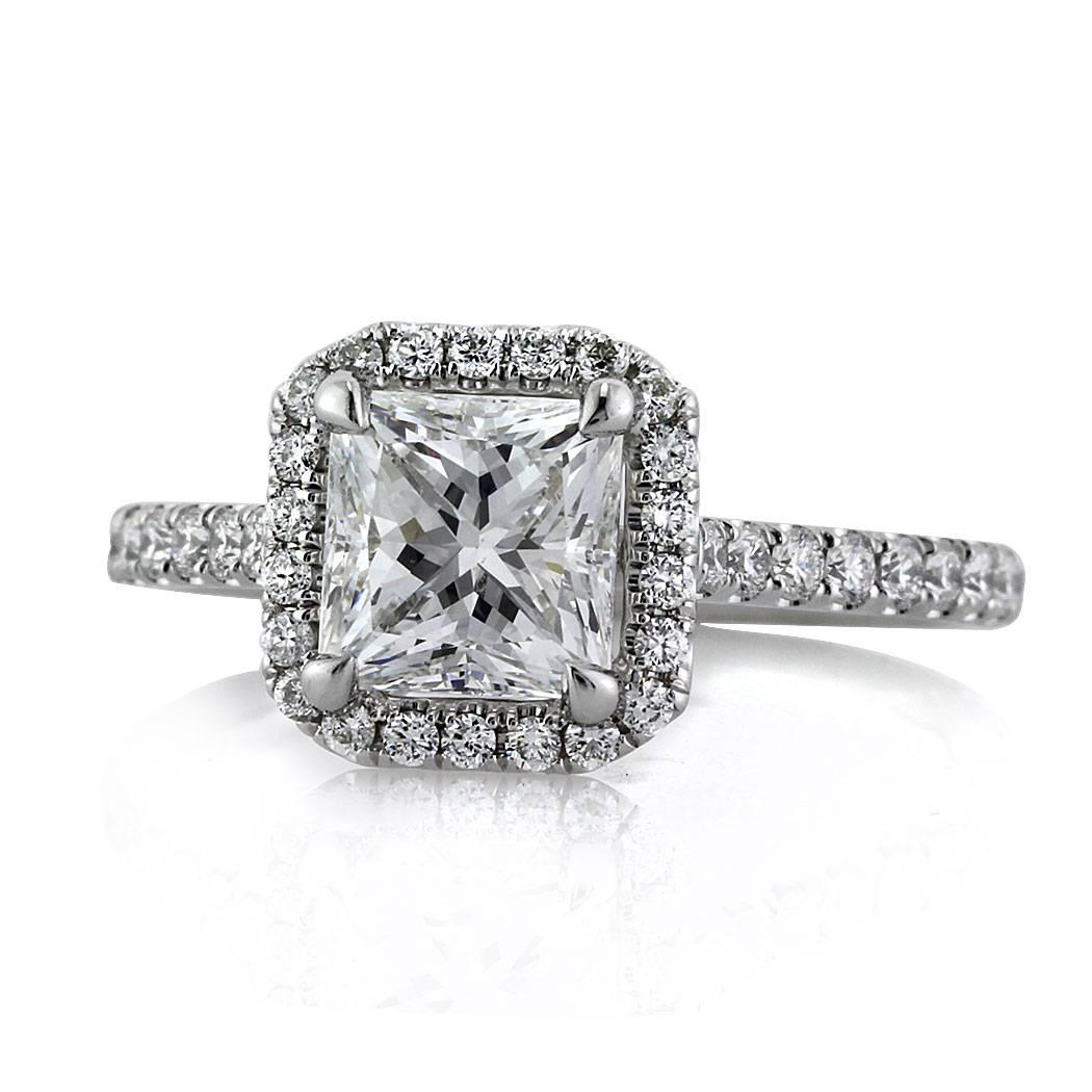 This stunning diamond engagement ring features an incredible 1.52ct princess cut center diamond, GIA certified at D-VS2. It is accented by a halo of round brilliant cut diamonds as well as one row of shimmering diamonds micro pavé set around the