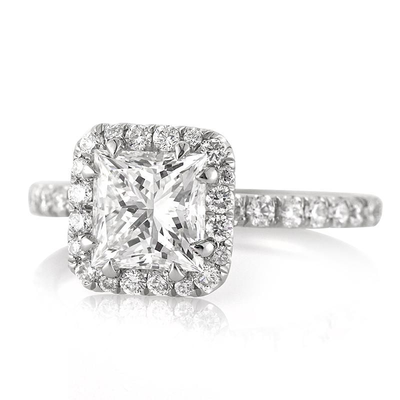 This captivating diamond engagement ring showcases a gorgeous 1.66ct princess cut center diamond, GIA certified at G-VS1. It is encased in a shimmering halo of round brilliant cut diamonds and complimented by one row of sparkling diamonds micro pavé