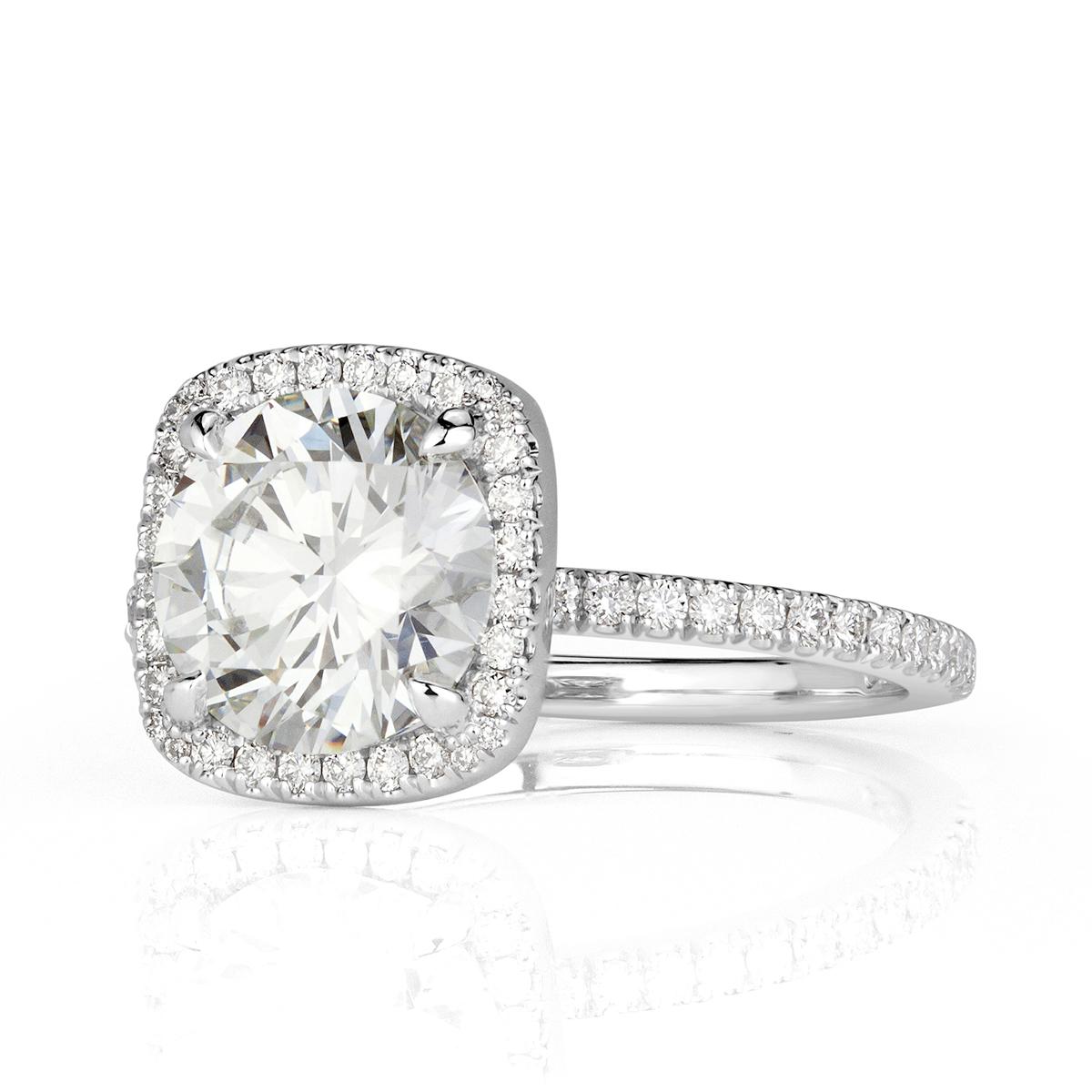 Realizzato in platino, questo splendido anello di fidanzamento con diamante mette in mostra uno splendido diamante centrale rotondo taglio brillante da 2,01 carati, certificato GIA I-VS1. È impreziosito da una scintillante aureola a forma di cuscino