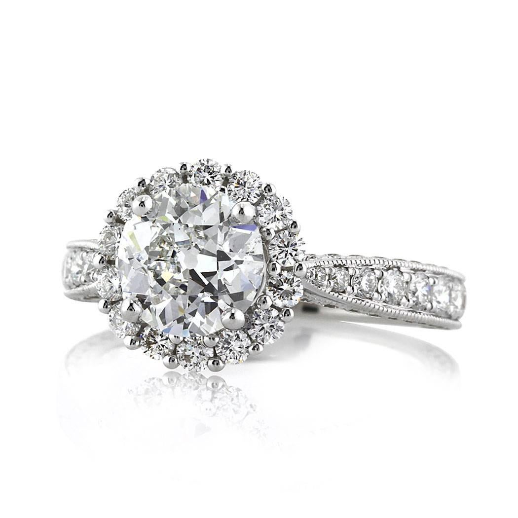 Created in 18k white gold, this gorgeous old European cut diamond engagement ring features a 1.51ct center diamond, GIA certified at F-SI1. It is accented by a halo of round brilliant cut diamonds as well as one row of glistening diamonds pavé set