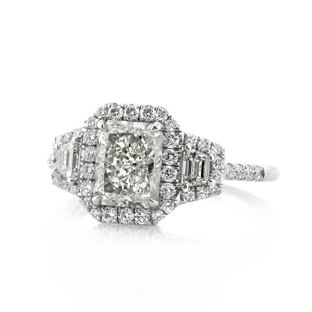 Created in platinum, this three-stone diamond engagement ring features a 1.70ct radiant cut center diamond, GIA certified at H- VVS2. It is flanked by two trapezoid cut diamonds on either side and set atop a dainty micro pavé shank. For maximum