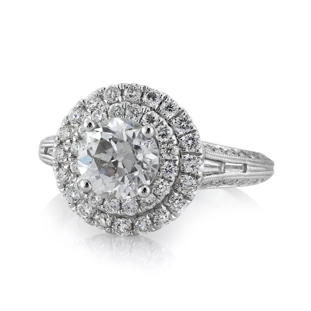 Custom created in 18k white gold, this one-of-a-kind diamond engagement ring showcases a 1.42ct old European center diamond, GIA certified at F-VS2. It is accented by a double halo of round brilliant cut diamonds as well as on row of baguette cut